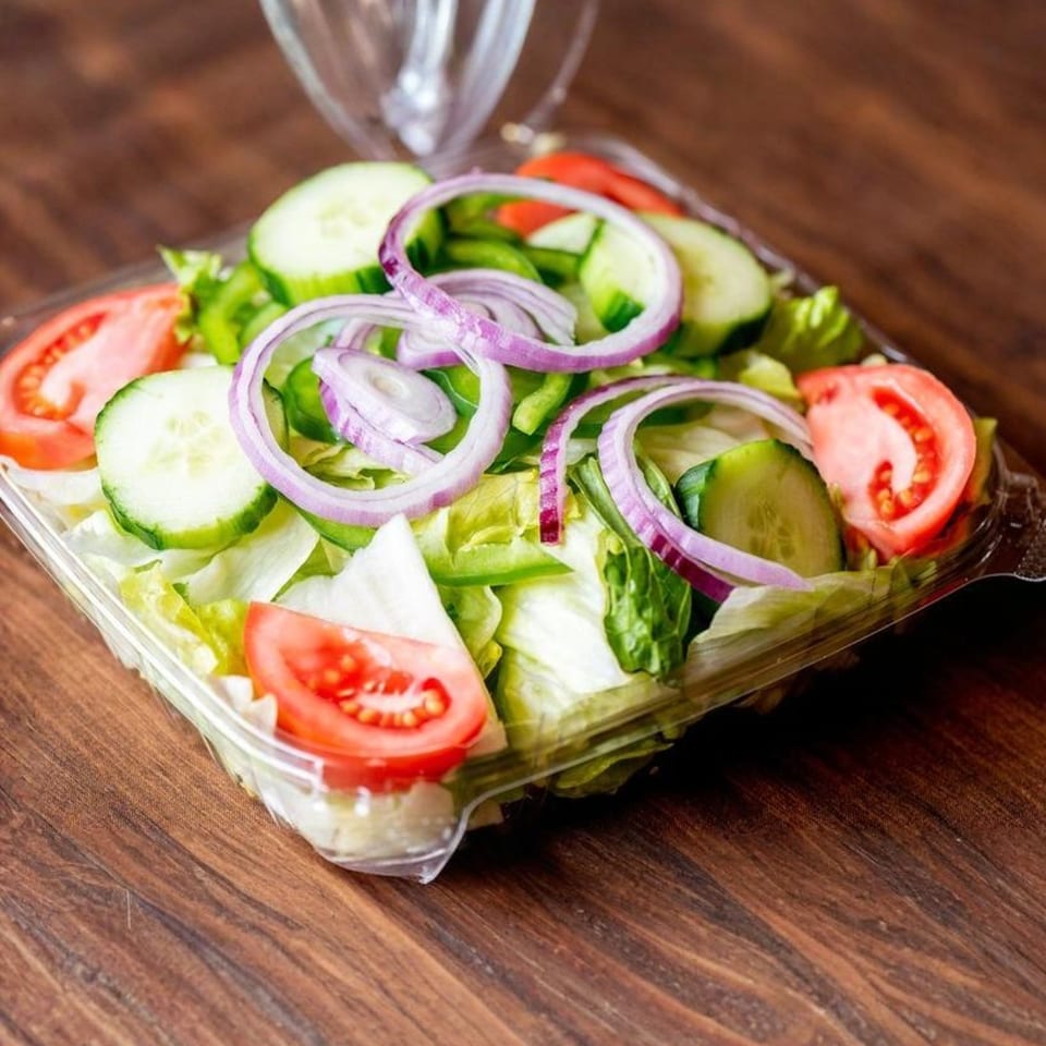 Fresh garden salad from Nicolini House of Pizza with lettuce, tomatoes, cucumbers, and red onions.