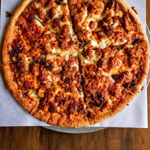 A freshly baked, sliced Nicolini House of Pizza pizza with generous toppings and melted cheese.