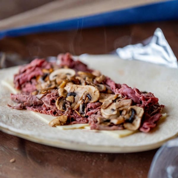 Nicolini House of Pizza's steak and mushroom sub filling, with cheese, on a flatbread.
