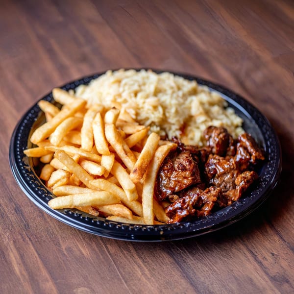 A black plate holds golden french fries, rice, and saucy beef tips on a wooden table.